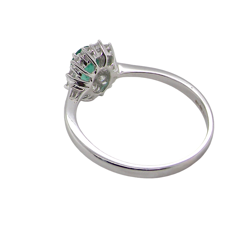 rear A classic cluster ring set with an oval cut emerald centre stone, measures 6x4mm, grass green colour.
Complimented by an outer halo of twelve brilliant cut white diamonds, each 1.7mm (total est at 0.25 carats)