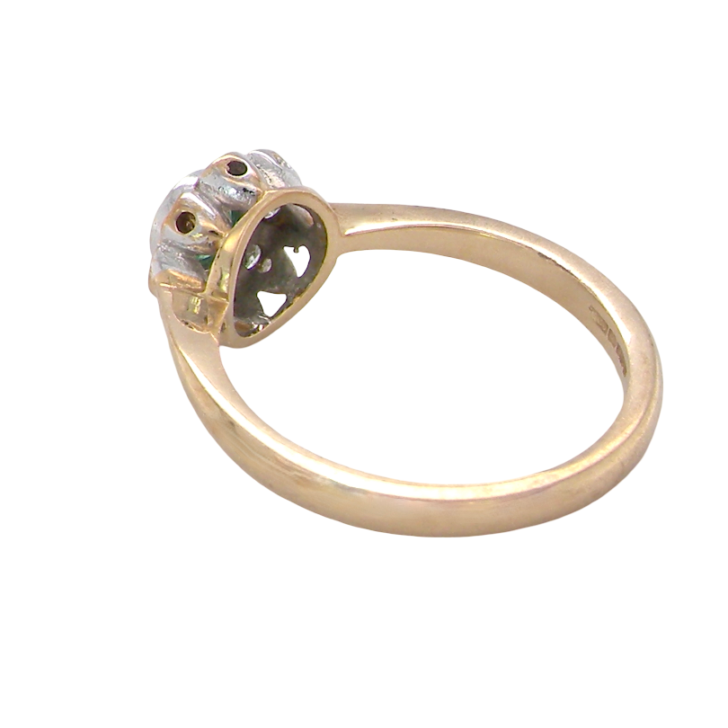A yellow gold ring with a decorative, multi-pronged setting holding a clear gemstone, shown on a plain white background.
