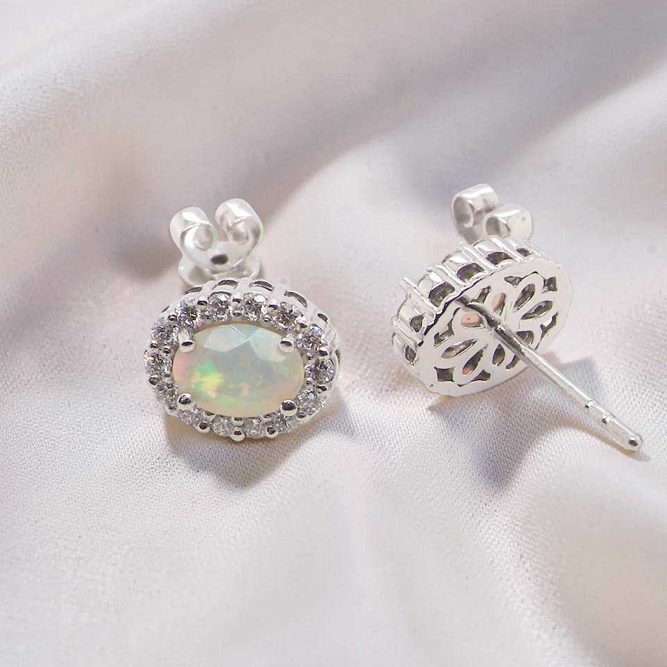 rear A fine and elegant pair of platinum* stud earrings, each beautifully set with an exceptional white opal measuring 7 x 5mm. T