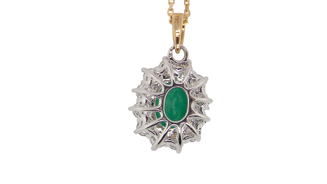rear A fine cluster pendant. Features at the centre an oval cut emerald, measures 7.5x5mm (est one carat). Dark green hue, natural inclusions.