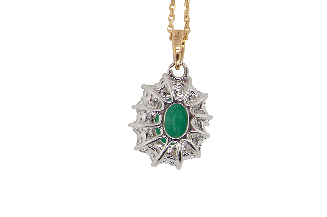 rear A fine cluster pendant. Features at the centre an oval cut emerald, measures 7.5x5mm (est one carat). Dark green hue, natural inclusions.