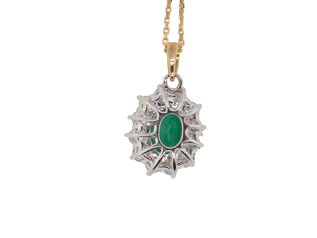 rear A fine cluster pendant. Features at the centre an oval cut emerald, measures 7.5x5mm (est one carat). Dark green hue, natural inclusions.