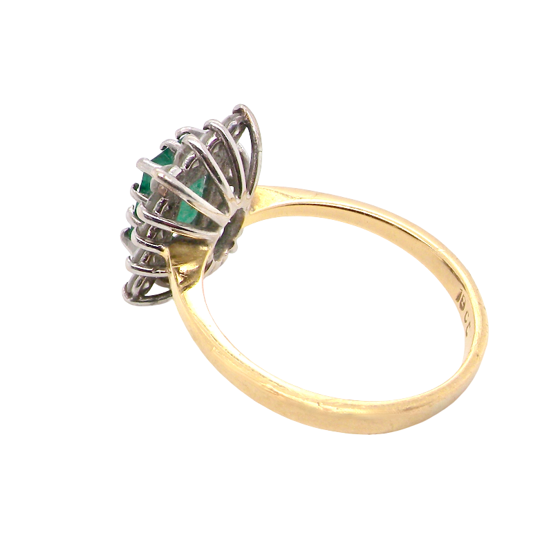 rear A fine cluster ring that features a rectangular mid to dark green emerald, measures 8x6mm (est 0.50 carats) 