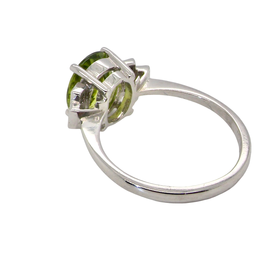 rear A fine gem set ring featuring a vibrant lime-green oval faceted peridot,