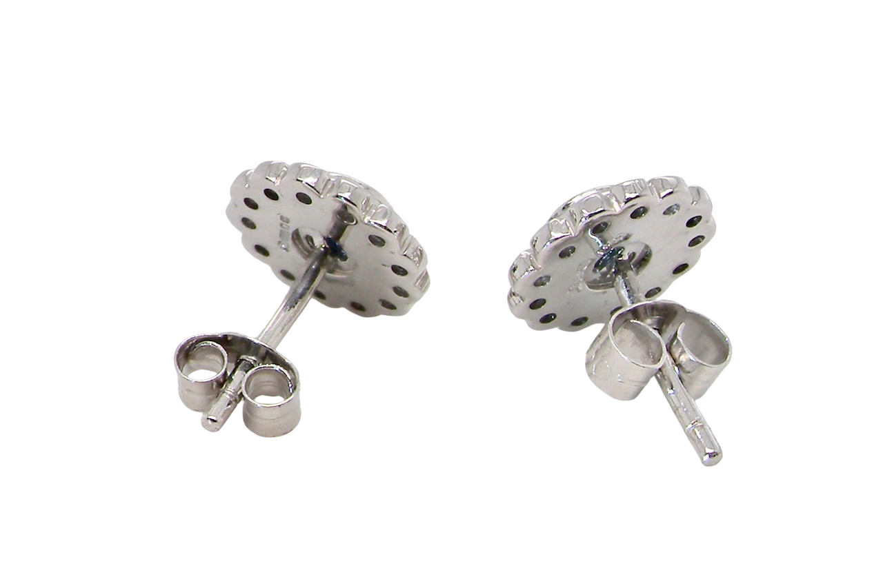 rear A fine pair of 18 carat white gold sapphire and diamond cluster earrings.
Each earring is set with a central round sapphire measuring approximately 3.4mm in diameter, estimated at 0.15ct,