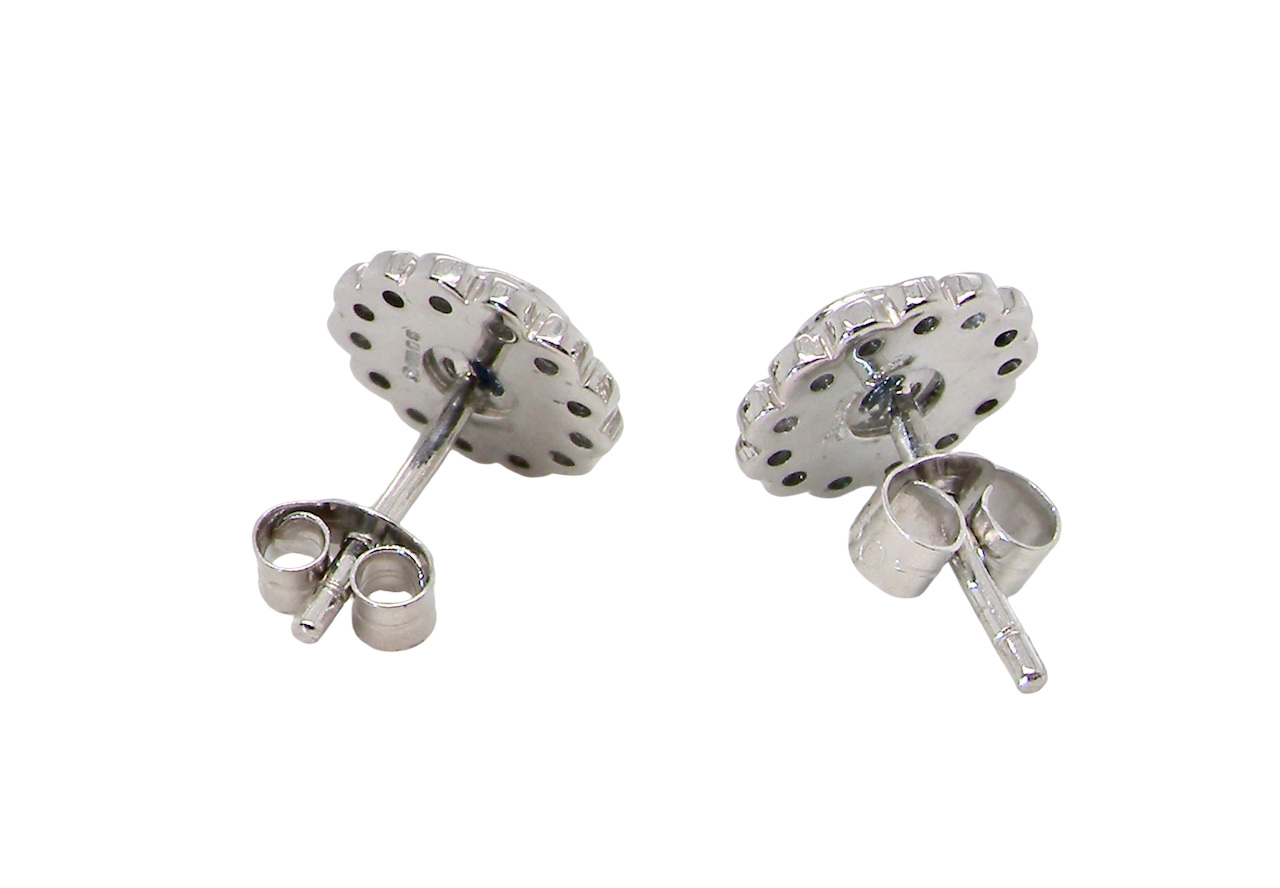 rear A fine pair of 18 carat white gold sapphire and diamond cluster earrings.
Each earring is set with a central round sapphire measuring approximately 3.4mm in diameter, estimated at 0.15ct,