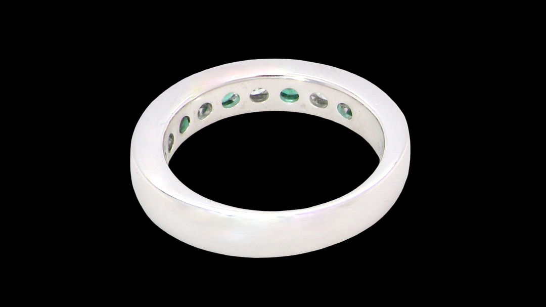 rear A fine platinum half hoop eternity ring. This is a new ring*. Channel set gem stones, five bright green emeralds 2.6mm each (0.54 carats total)