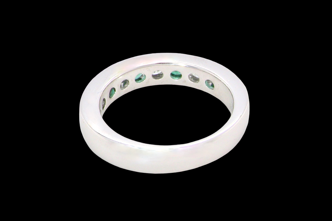 rear A fine platinum half hoop eternity ring. This is a new ring*. Channel set gem stones, five bright green emeralds 2.6mm each (0.54 carats total)