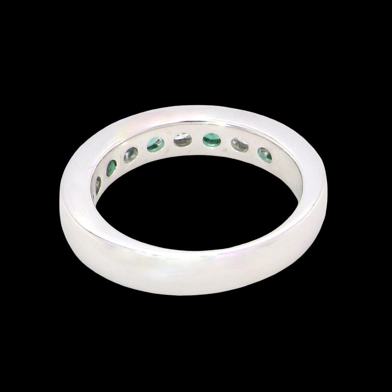 rear A fine platinum half hoop eternity ring. This is a new ring*. Channel set gem stones, five bright green emeralds 2.6mm each (0.54 carats total)