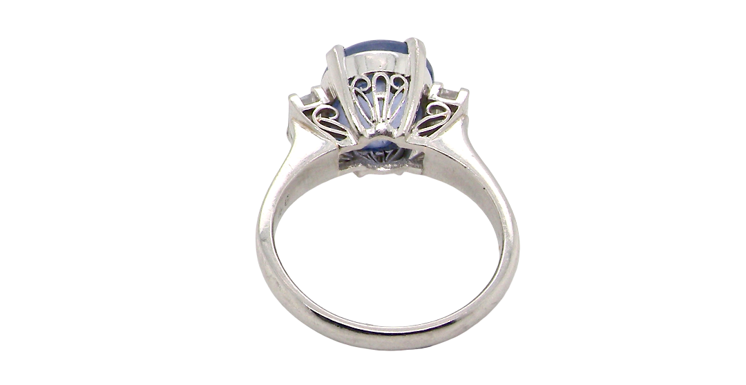 rear A fine platinum* ring. Features a lovely sky blue sapphire with 'star sapphire ' chatoyancy , measures 10x9mm, (est 4 carats) held by four claws, cabouchon cut