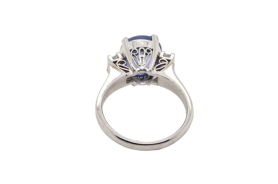rear A fine platinum* ring. Features a lovely sky blue sapphire with 'star sapphire ' chatoyancy , measures 10x9mm, (est 4 carats) held by four claws, cabouchon cut