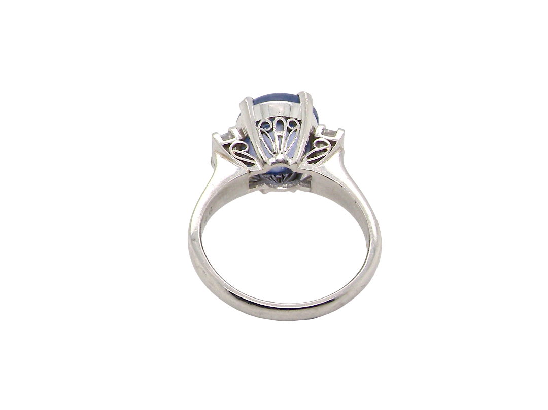 rear A fine platinum* ring. Features a lovely sky blue sapphire with 'star sapphire ' chatoyancy , measures 10x9mm, (est 4 carats) held by four claws, cabouchon cut
