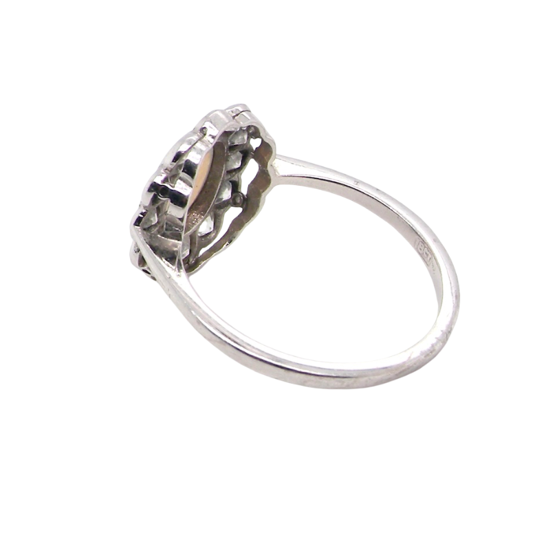 rear A fine vintage cluster ring. Features to the centre an oval shaped opal, with excellent play of colour, pink to one way, vibrant green to the other with flashes of electric blue also within the body of the gem.