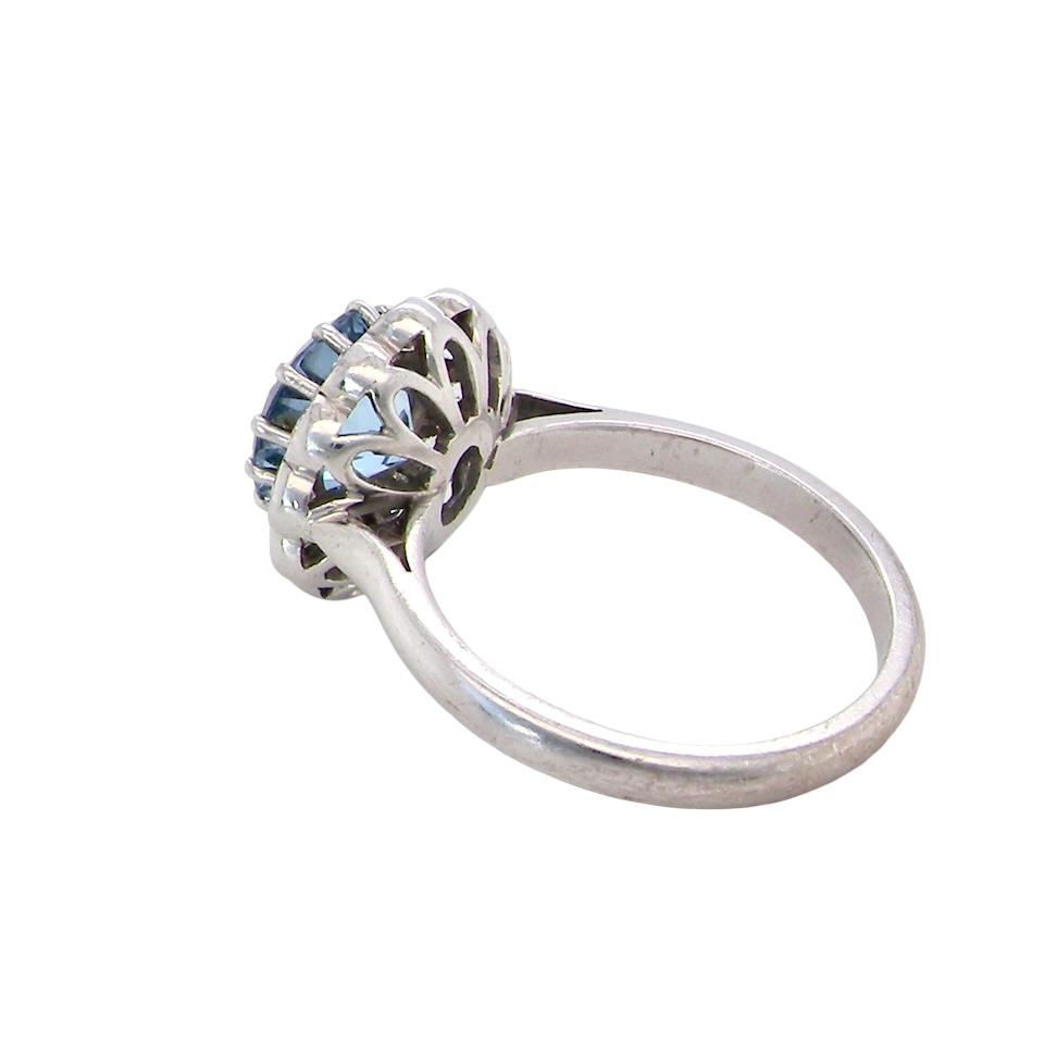 rear A fine vintage cluster ring centred with a deep blue aquamarine, measuring approximately 8mm and estimated at 2 carats, securely claw set.