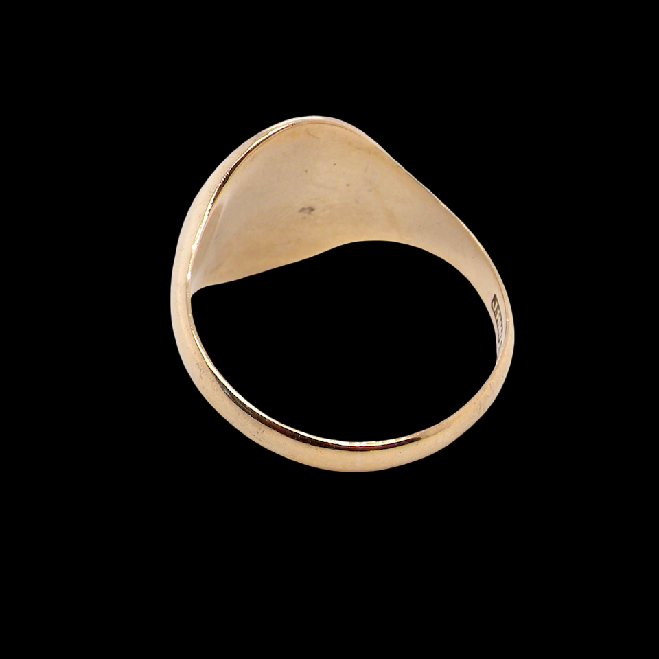 rear A gentlemans 9 carat gold signet ring. The head is oval with a slight pattern to the outer edges. 