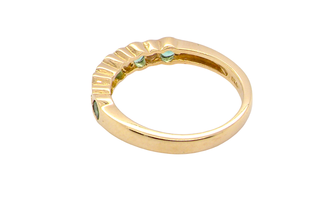 rear A half hoop eternity ring. Set with five round emeralds, each 3mm (0.10 carats) and set with an alternate brilliant cut white diamond, 2.4mm each (total 0.20 carats)
