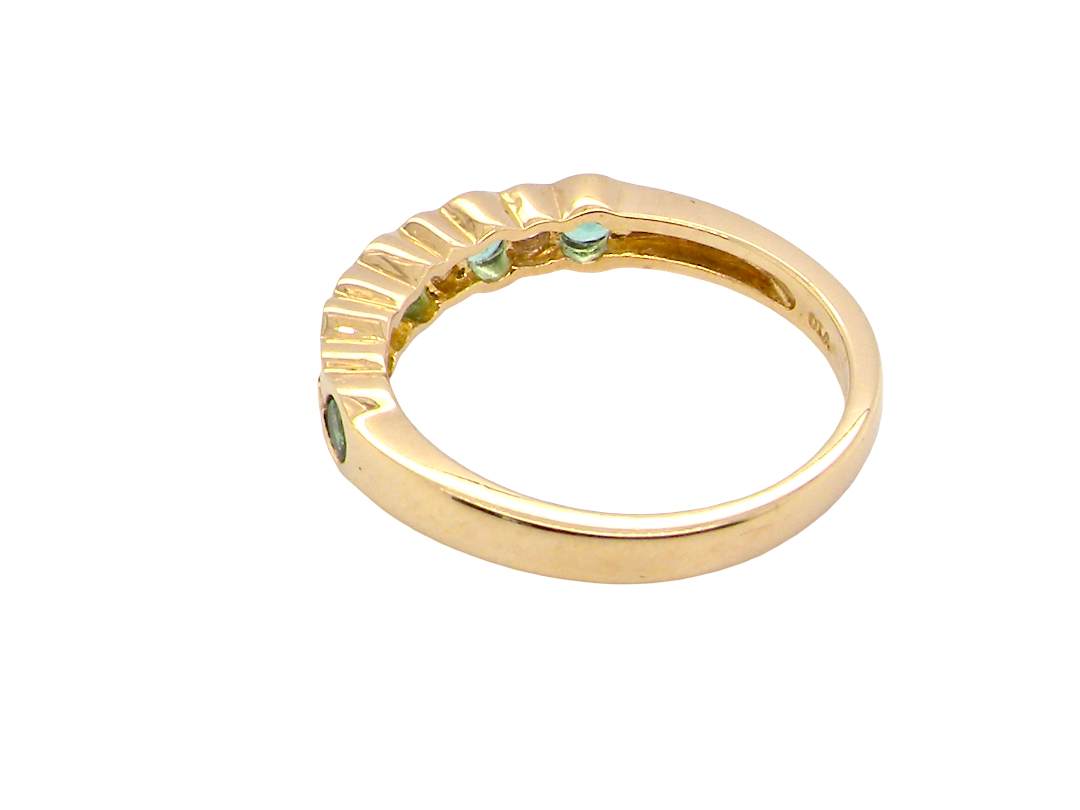 rear A half hoop eternity ring. Set with five round emeralds, each 3mm (0.10 carats) and set with an alternate brilliant cut white diamond, 2.4mm each (total 0.20 carats)