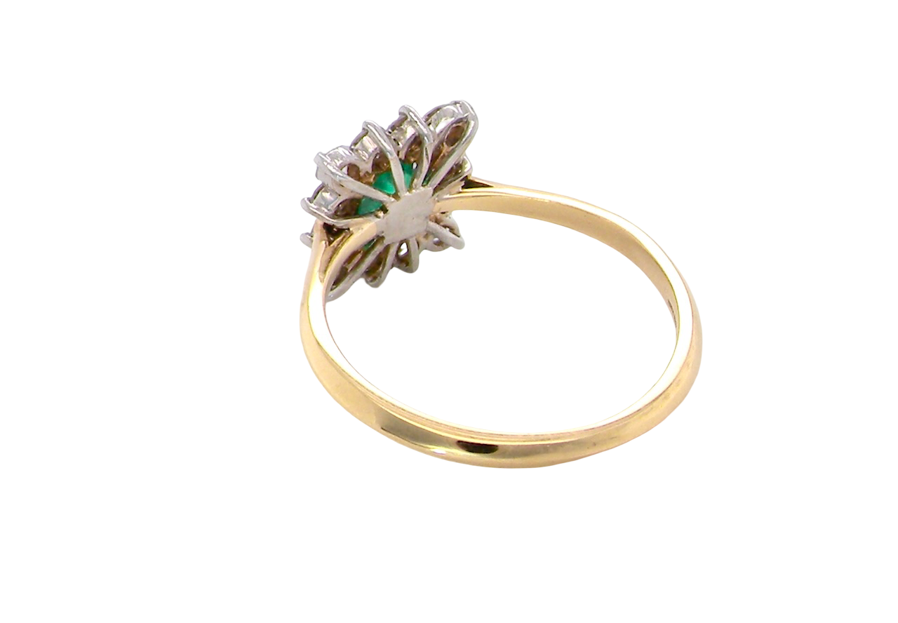 rear A lovely cluster ring that features to the centre a rectangle shaped emerald, 7x5mm. Shows a deep grass green colour which does have natural inclusions common with most emeralds, but the depth of colour is impressive.