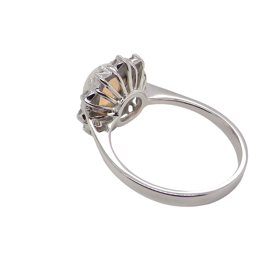 rear A lovely white gold cluster ring. Features to the centre an oval white opal, 9x7mm, with an excellent play of colour.