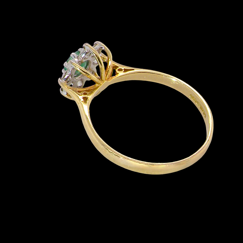 rear A pretty 18 carat gold cluster ring. The centre stone is a round emerald 4mm diameter (0.25 carats) mid green colour.