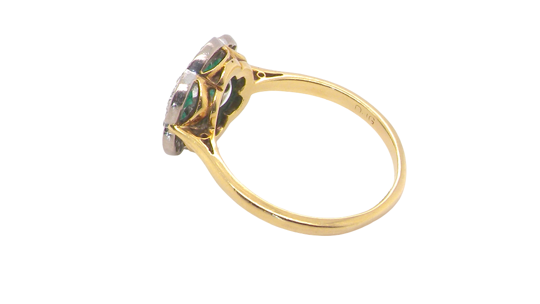 rear A pretty cluster ring. Features emeralds and diamonds. Centre stone a brilliant cut white diamond, measures 4mm (0.25 carats). 