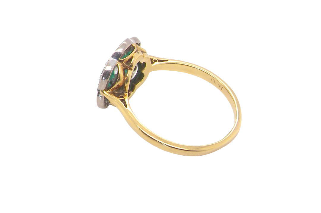rear A pretty cluster ring. Features emeralds and diamonds. Centre stone a brilliant cut white diamond, measures 4mm (0.25 carats). 