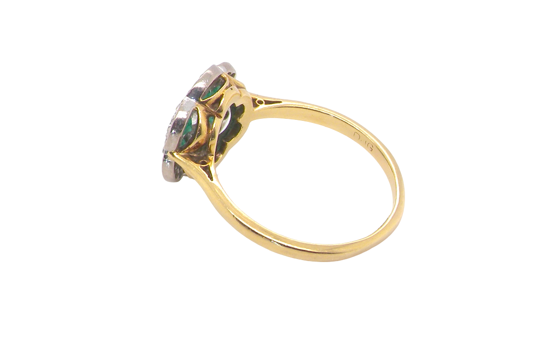 rear A pretty cluster ring. Features emeralds and diamonds. Centre stone a brilliant cut white diamond, measures 4mm (0.25 carats). 