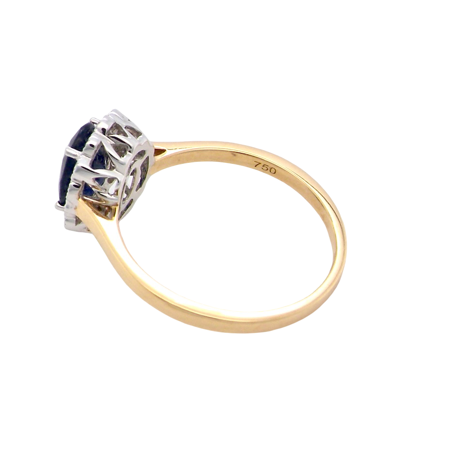 rear A pretty cluster ring that features an inky black blue sapphire that measures 8x6mm. Complimented by an outer border of diamonds