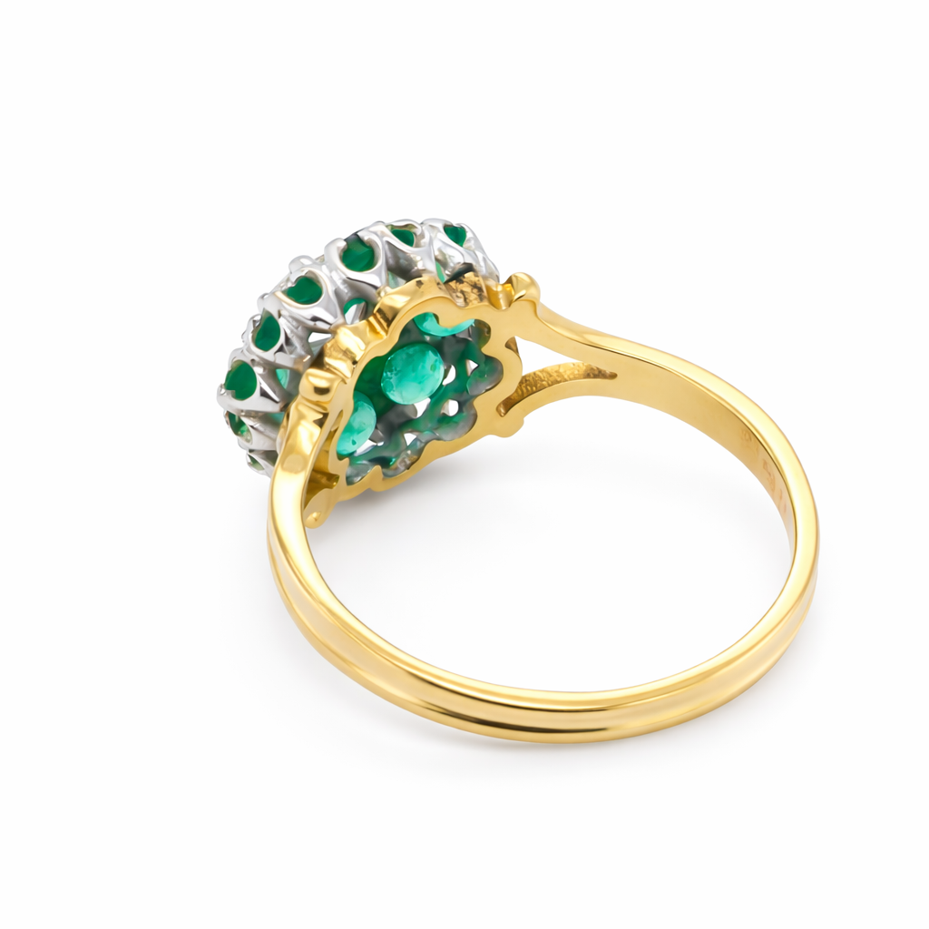 rear A pretty cluster ring that features to the centre a round emerald