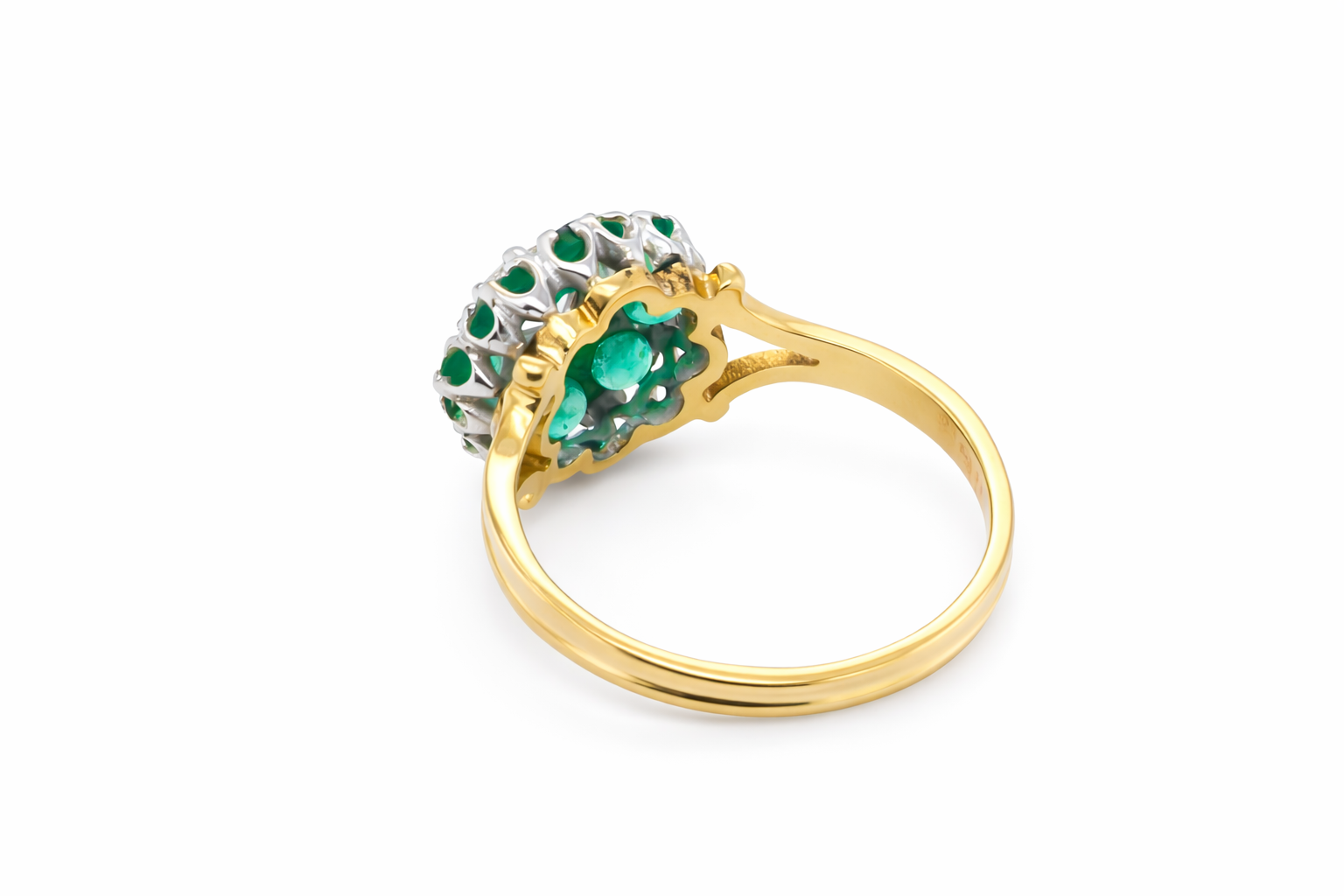 rear A pretty cluster ring that features to the centre a round emerald
