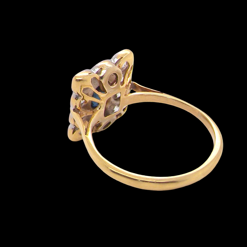 rear A rectangular cluster ring that features in its centre a cushion shaped dark blue sapphire, that measures 5x3.5mm (est 0.30 carats)