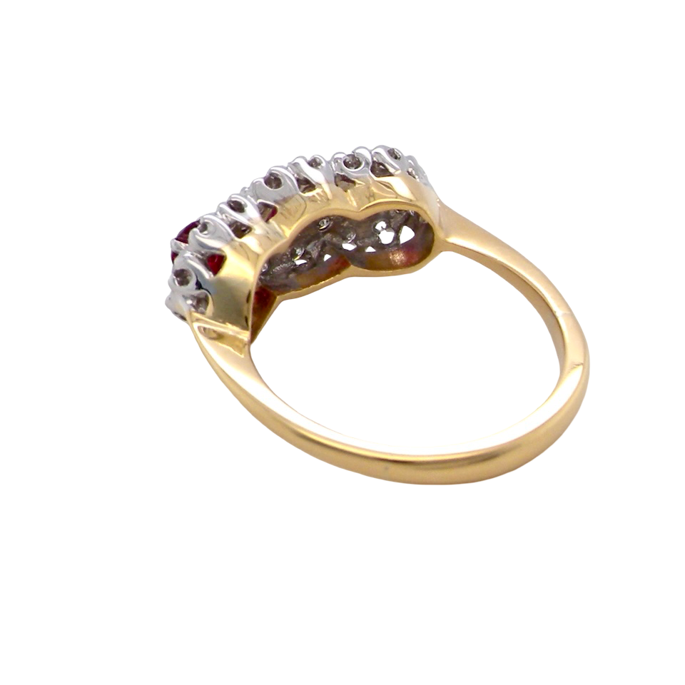 rear A striking  cluster ring crafted in 18 carat gold, dating circa 1990–2000, and fully hallmarked in the UK.
✨ Design & Gemstones
Three deep red rubies set to the centre of each cluster