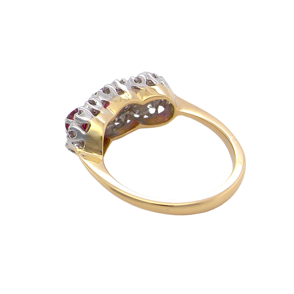 rear A striking triple cluster ring crafted in 18 carat gold, dating circa 1990–2000, and fully hallmarked in the UK.
✨ Design & Gemstones
Three deep red rubies set to the centre of each cluster