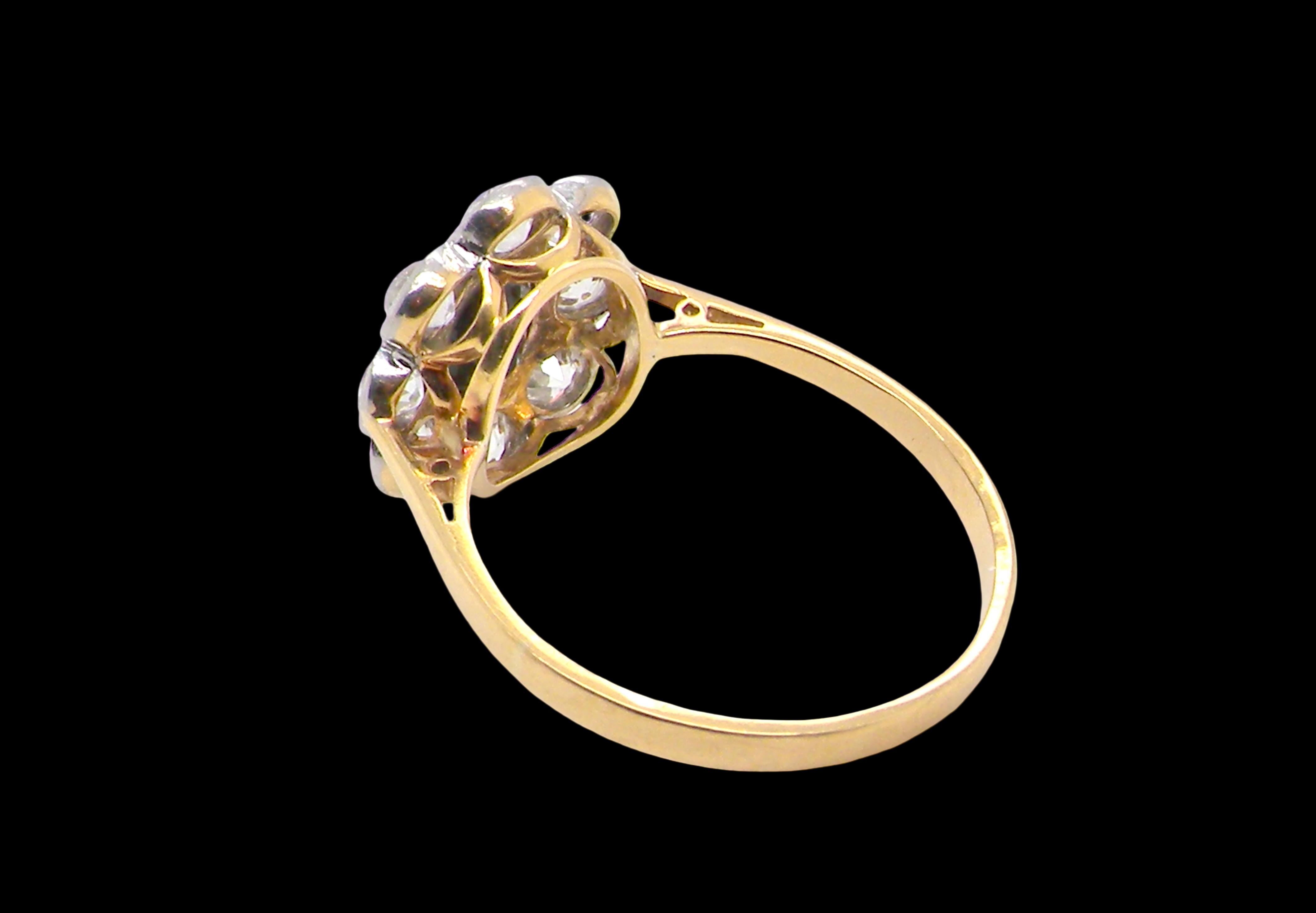rear A striking vintage sapphire and diamond cluster ring dating from the 1930s–1940s, beautifully crafted in platinum and 18 carat gold. At the centre sits a richly coloured oval-cut sapphire of deep inky blue-black hue, measuring approximately 7 x 5mm and estimated at 0.75 carats.