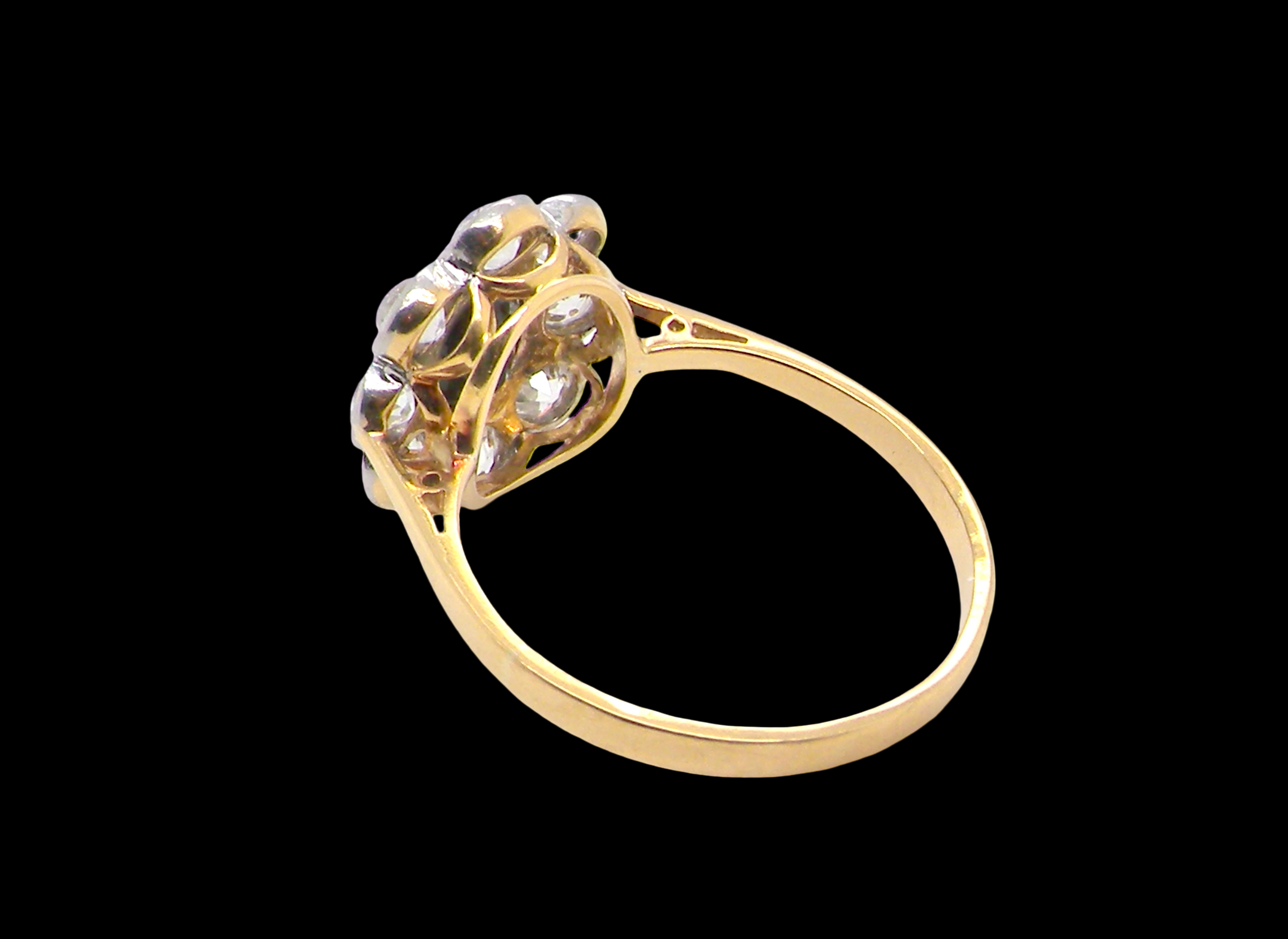 rear A striking vintage sapphire and diamond cluster ring dating from the 1930s–1940s, beautifully crafted in platinum and 18 carat gold. At the centre sits a richly coloured oval-cut sapphire of deep inky blue-black hue, measuring approximately 7 x 5mm and estimated at 0.75 carats.