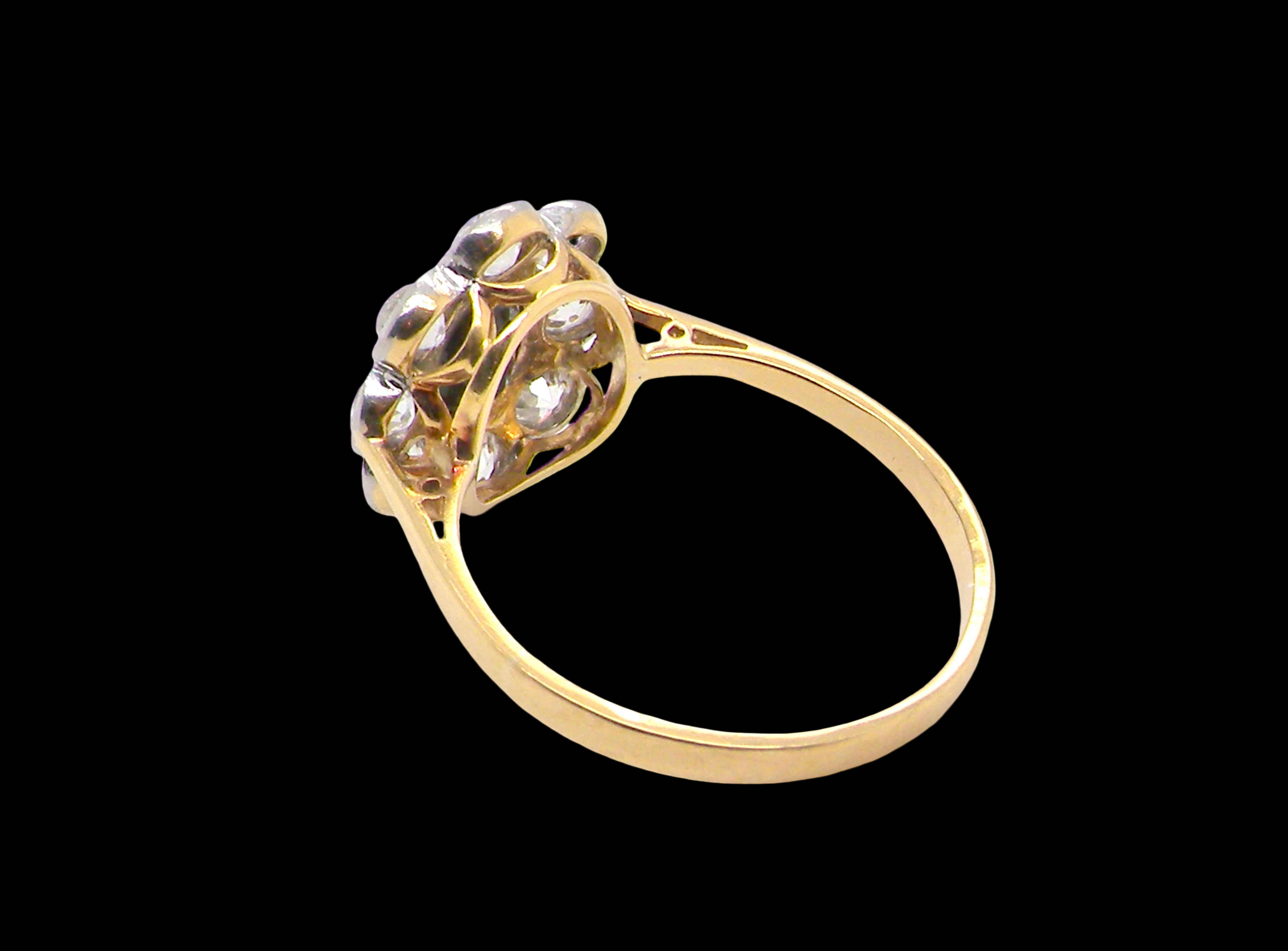 rear A striking vintage sapphire and diamond cluster ring dating from the 1930s–1940s, beautifully crafted in platinum and 18 carat gold. At the centre sits a richly coloured oval-cut sapphire of deep inky blue-black hue, measuring approximately 7 x 5mm and estimated at 0.75 carats.