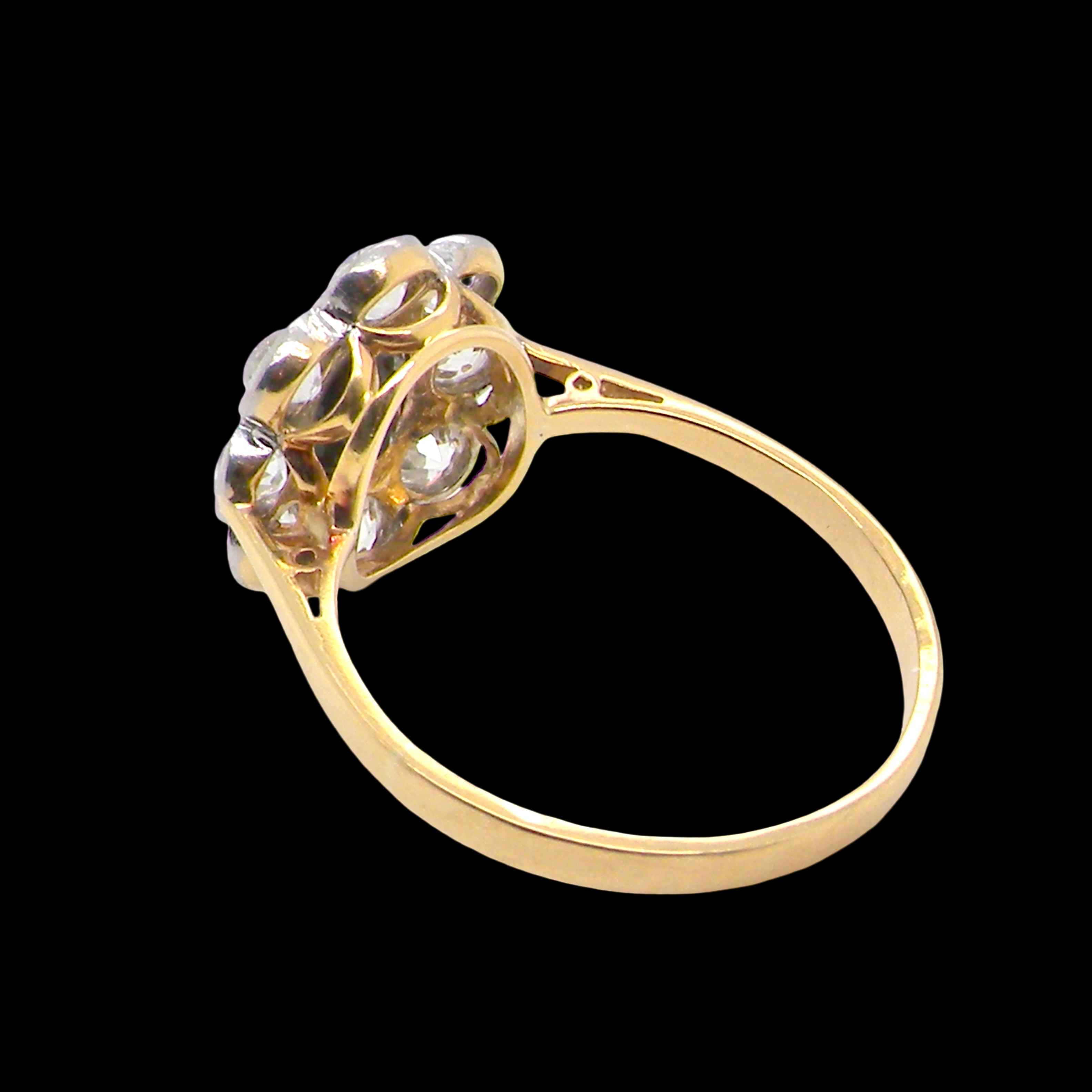 rear A striking vintage sapphire and diamond cluster ring dating from the 1930s–1940s, beautifully crafted in platinum and 18 carat gold. At the centre sits a richly coloured oval-cut sapphire of deep inky blue-black hue, measuring approximately 7 x 5mm and estimated at 0.75 carats.