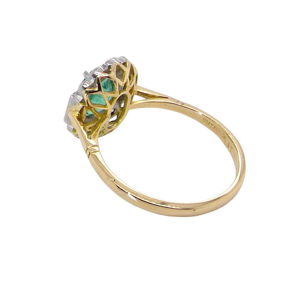 rear A stunning vintage cluster ring, set with an oval-cut emerald measuring 8 x 6mm, approximately 1.10 carats. The emerald displays a rich, deep grass-green colour with natural inclusions, typical of a genuine stone.