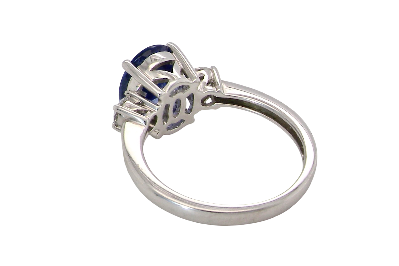 rear A three stone ring that features an impressive tanzanite centre stone that measures 10x8mm (3.21 carats confirmed) AAA colour. 