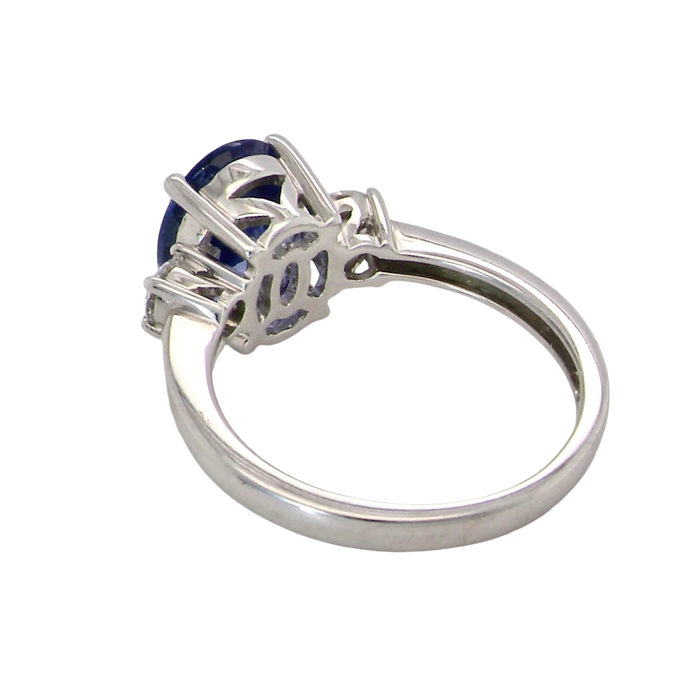 rear A three stone ring that features an impressive tanzanite centre stone that measures 10x8mm (3.21 carats confirmed) AAA colour. 