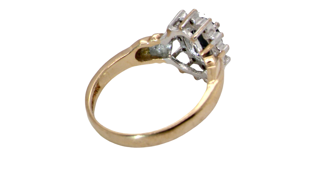 rear A traditional cluster ring that features to the centre a dark black blue oval cut sapphire 7x5mm (est 3/4 ct) claw set.