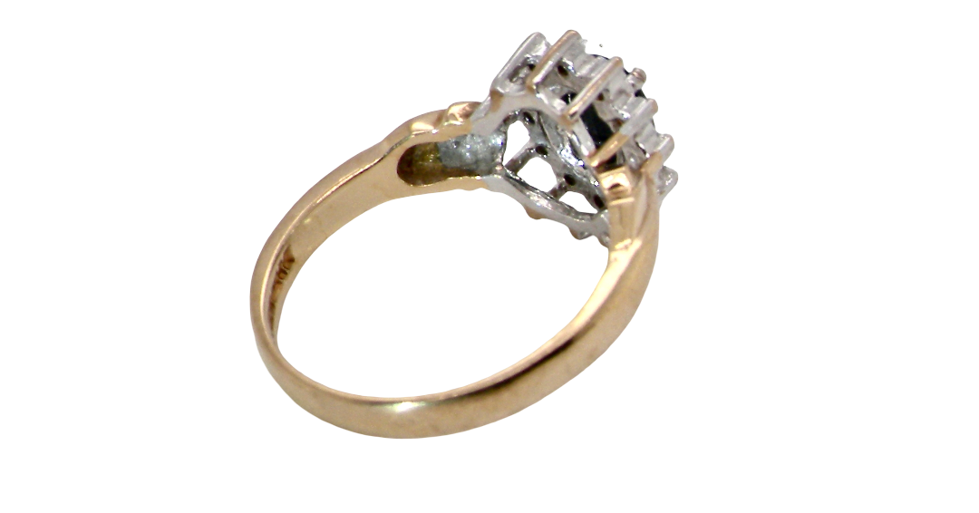 rear A traditional cluster ring that features to the centre a dark black blue oval cut sapphire 7x5mm (est 3/4 ct) claw set.