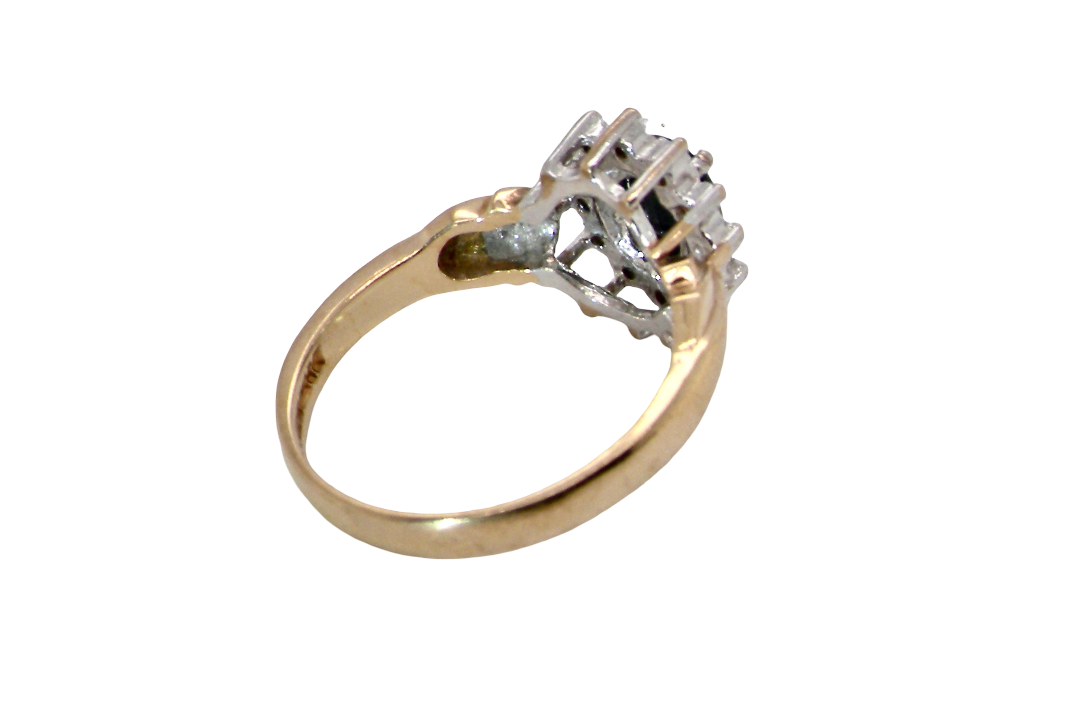 rear A traditional cluster ring that features to the centre a dark black blue oval cut sapphire 7x5mm (est 3/4 ct) claw set.