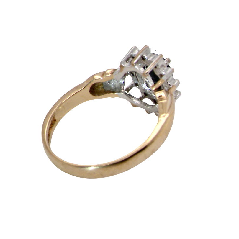 rear A traditional cluster ring that features to the centre a dark black blue oval cut sapphire 7x5mm (est 3/4 ct) claw set.