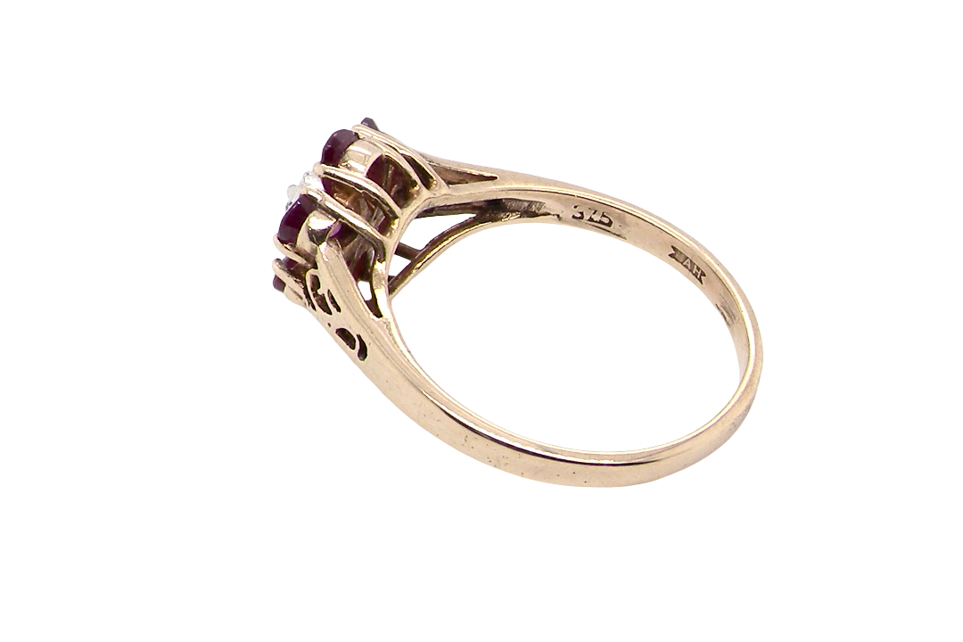 rear A very pretty 9 carat gold cluster ring. The centre stone a small illusion set diamond, 1.3mm
Surrounded by six pear shaped raspberry red rubies,