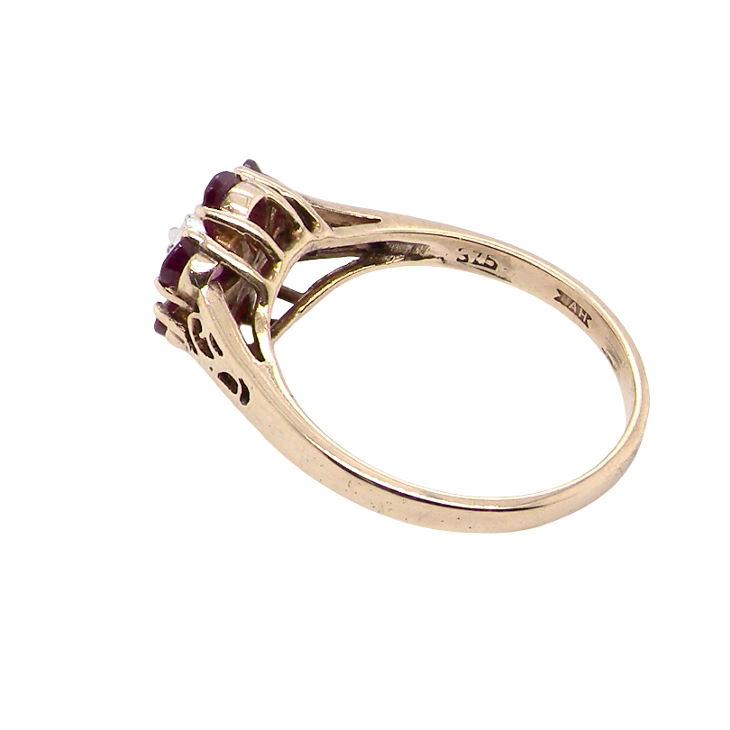 rear A very pretty 9 carat gold cluster ring. The centre stone a small illusion set diamond, 1.3mm
Surrounded by six pear shaped raspberry red rubies,