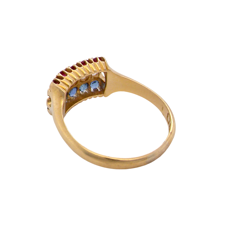 A vintage gold ring with a semi-circular cluster setting featuring three light blue round-cut stones and a row of small red stones above, shown on a plain white background.