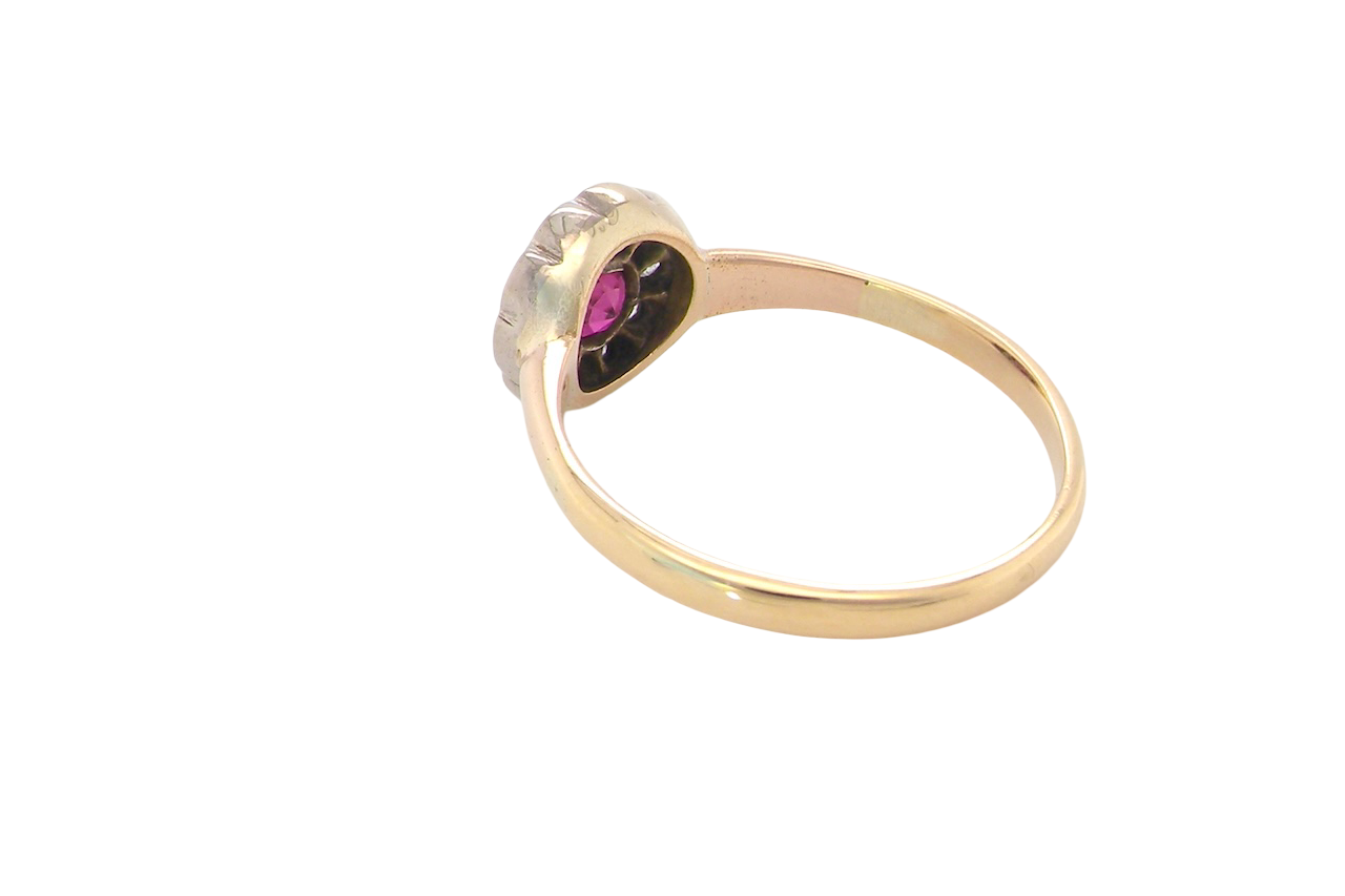 rear A very pretty vintage daisy cluster ring. Features to the centre a round pink red ruby that measures 4mm, and is mille grain set.