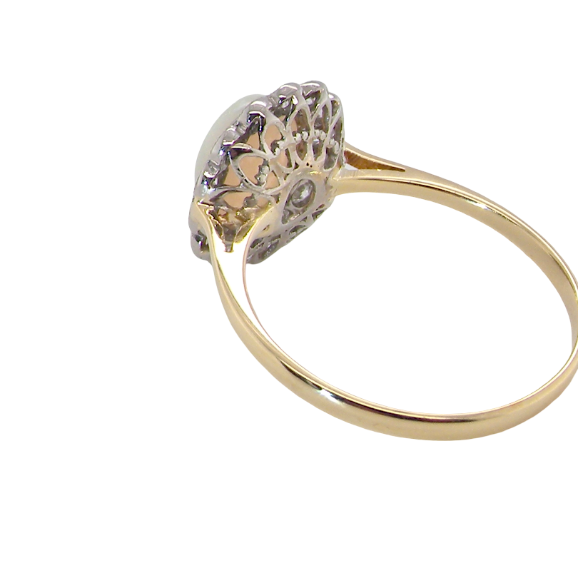 A yellow gold ring with a decorative filigree head set with small clear stones, shown on a plain white background.