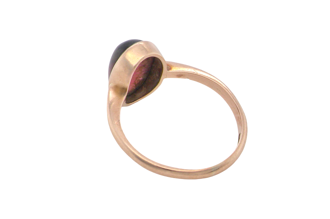 rear A vintage dress ring. Set with an oval cabouchon cut garnet, 11x7mm, in a rim style setting.